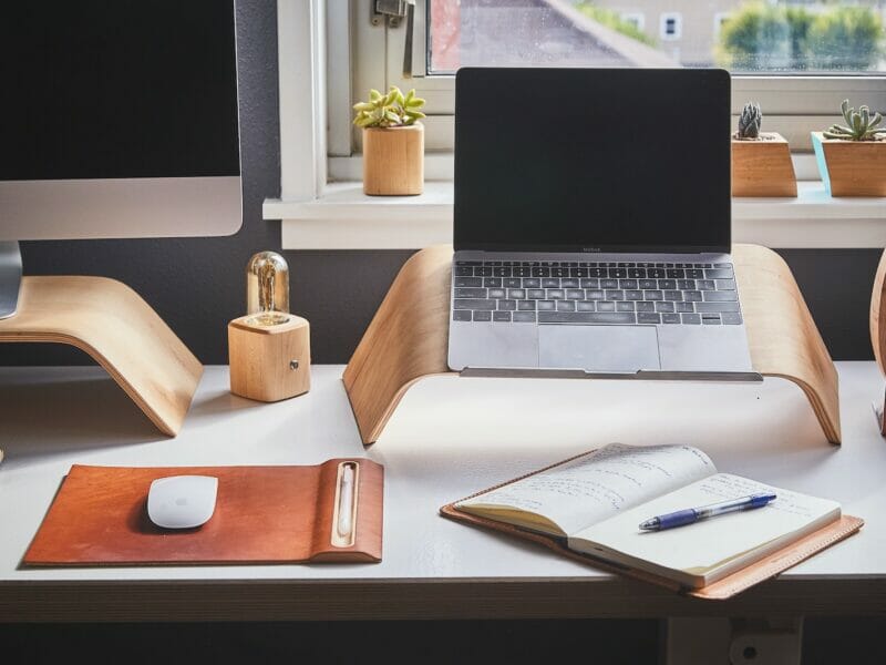 black and silver laptop on brown wooden rack