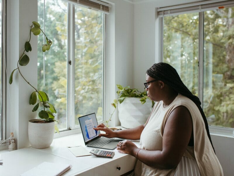 a woman sitting at a table with a laptop