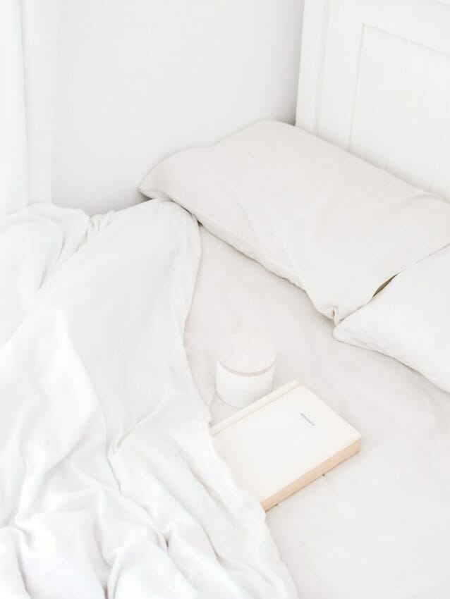white portable speaker on bed