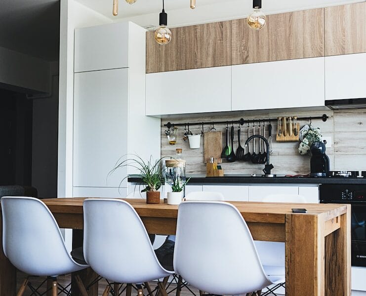 brown wooden dining table with white chairs near kitchen