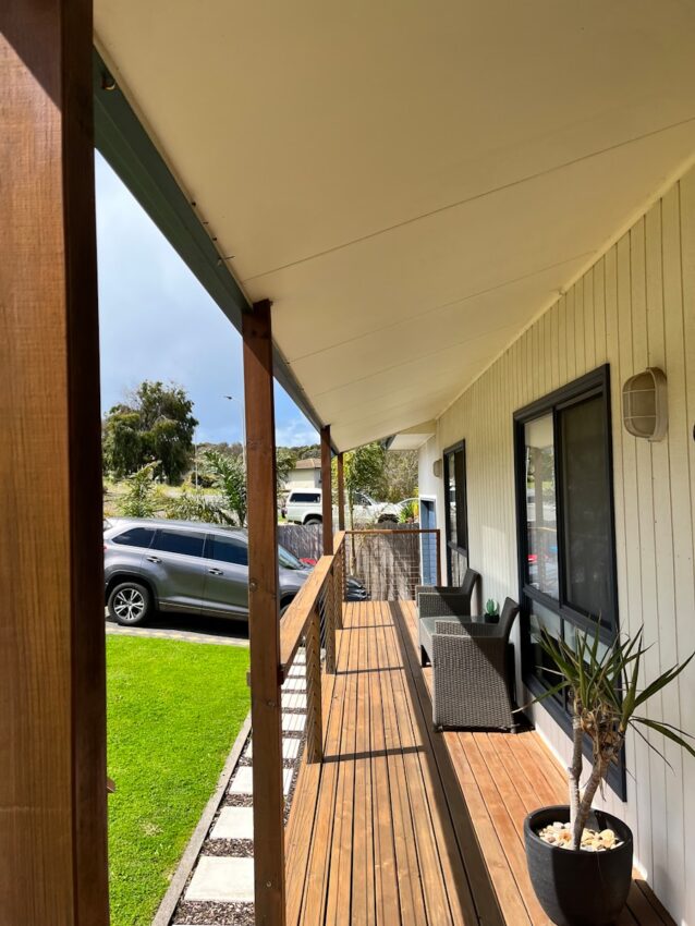 a porch with a plant on the side of it