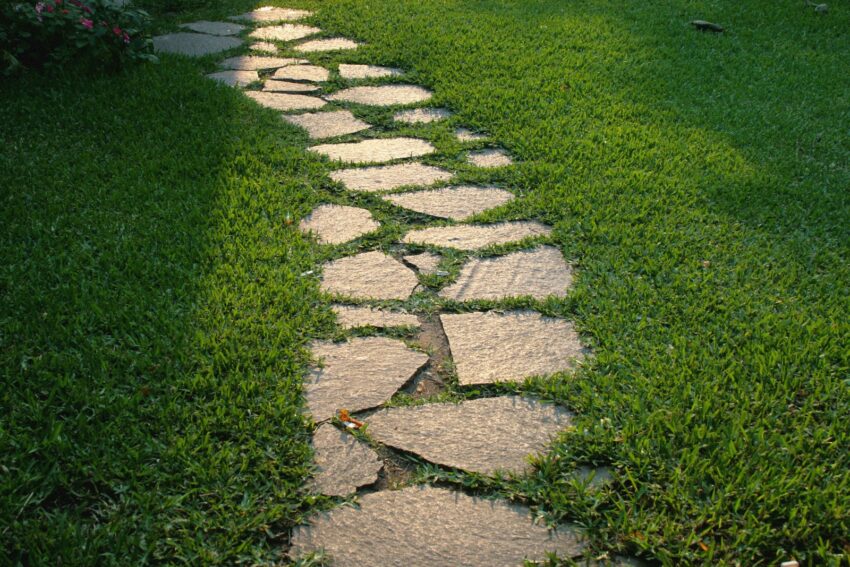 a stone path in the middle of a grassy area