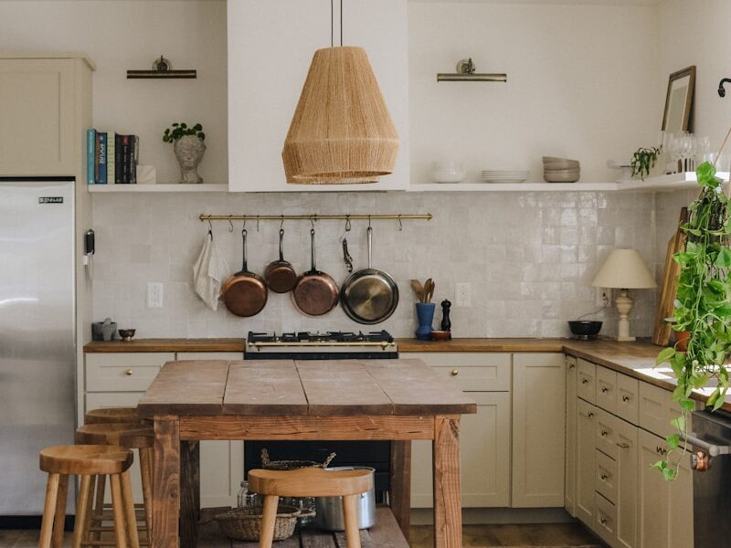 brown wooden seat beside white wooden kitchen cabinet