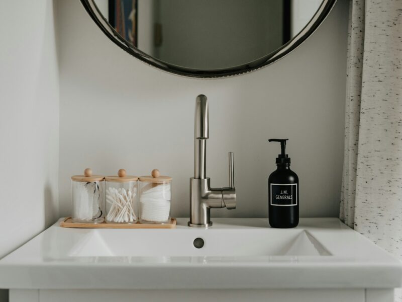 a bathroom sink with a soap dispenser next to it