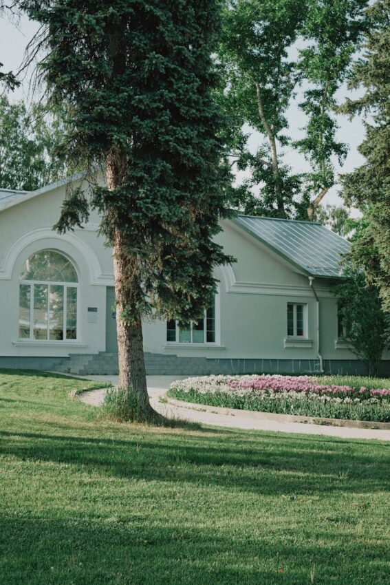 A white house sitting on top of a lush green field