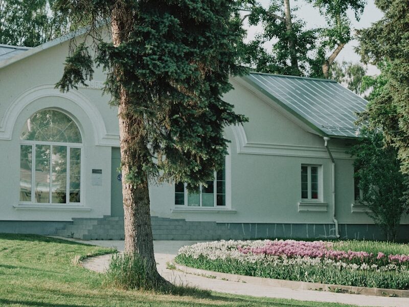 A white house sitting on top of a lush green field