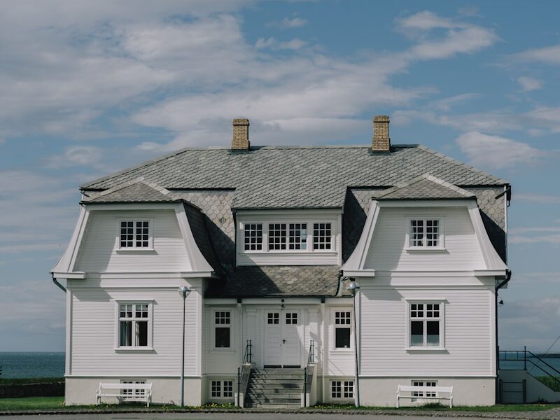 A large white house sitting on top of a lush green field