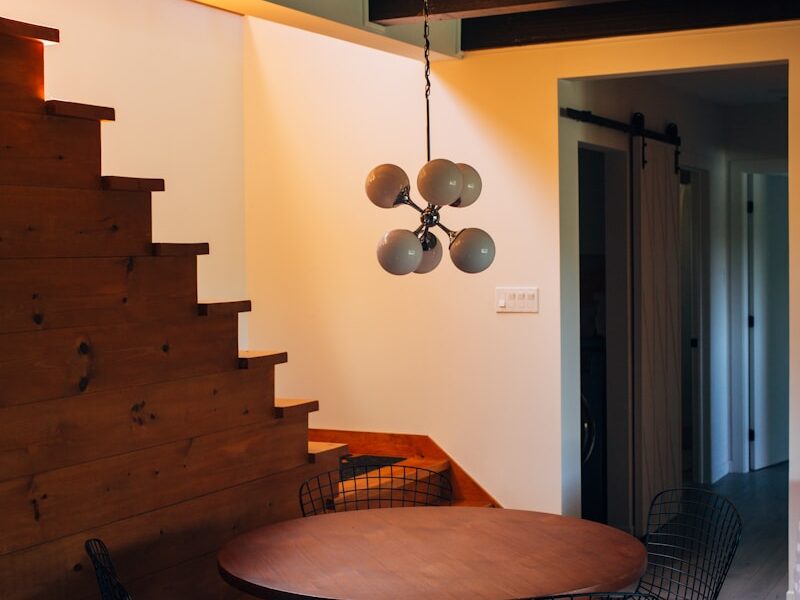 round brown wooden table and chairs under white pendant lamp
