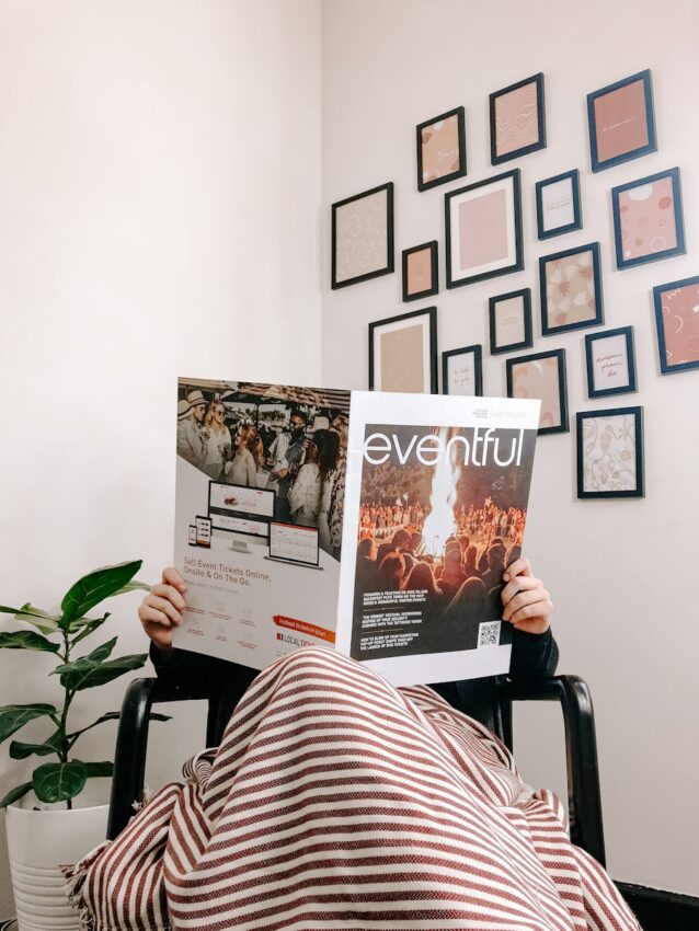 person sitting on armchair reading magazine