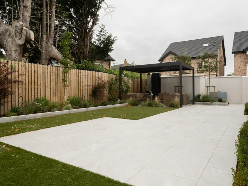 a backyard with a fence, grass and trees