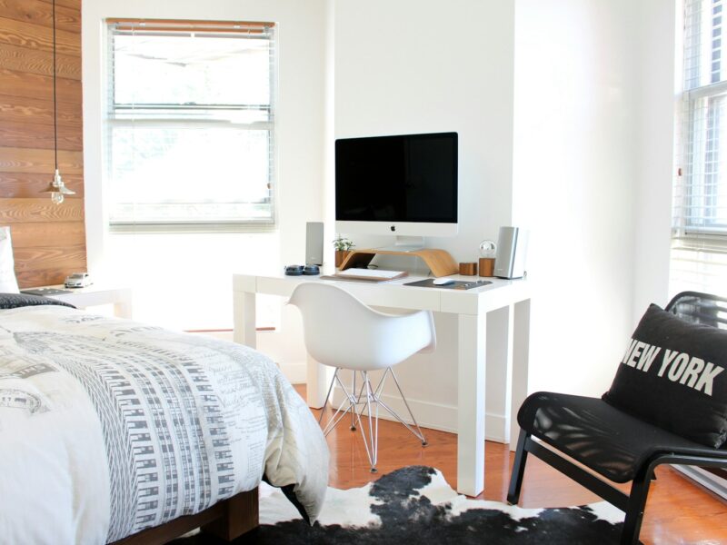 white wooden desk near bed inside the room