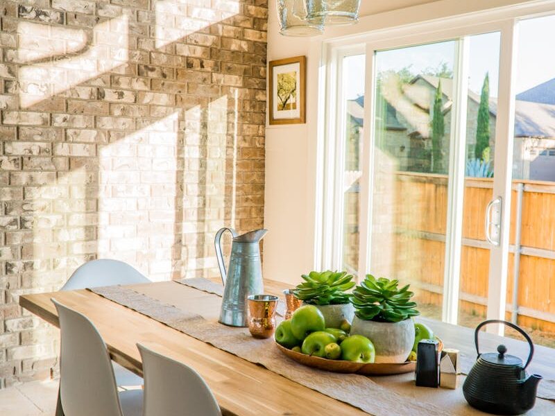 Black Kettle Beside Condiment Shakers and Green Fruits and Plants on Tray on Brown Wooden Table