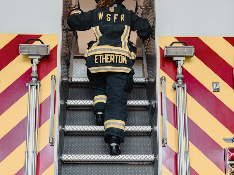 a fireman climbing the stairs of a fire truck