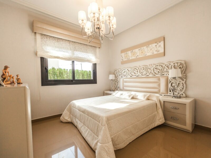 white bed comforter near glass window