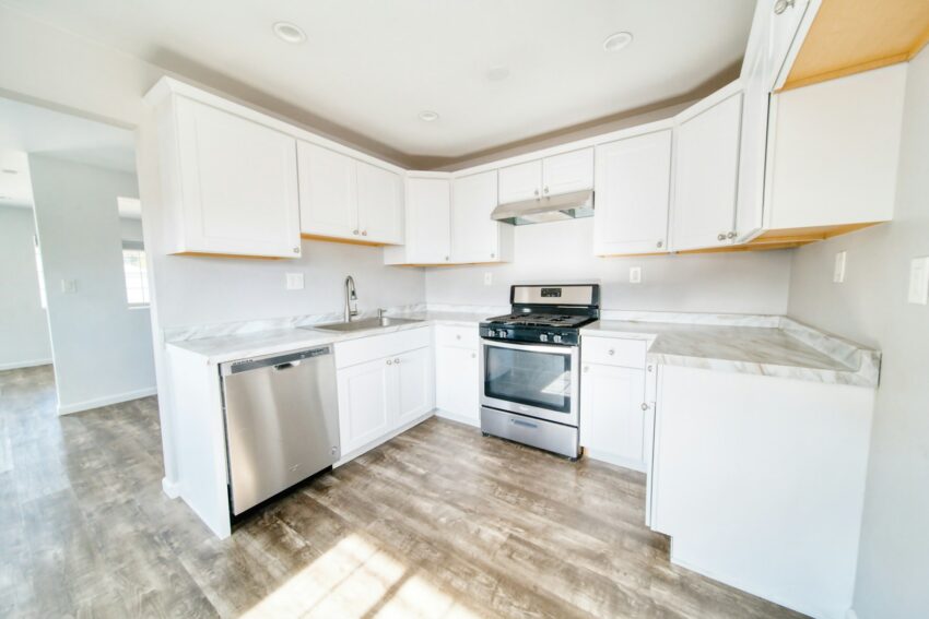 A kitchen with white cabinets and stainless steel appliances