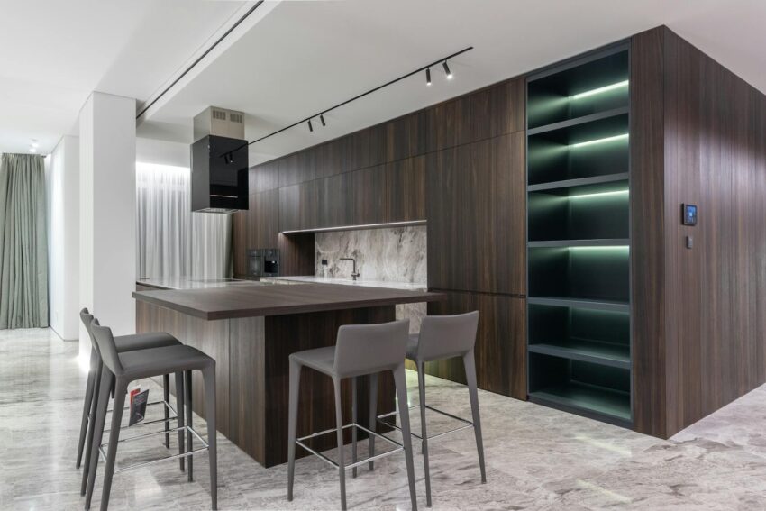 Modern interior design of contemporary spacious kitchen with dining zone and wooden furniture in apartment