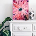 painting of pink flower on dresser near white vase