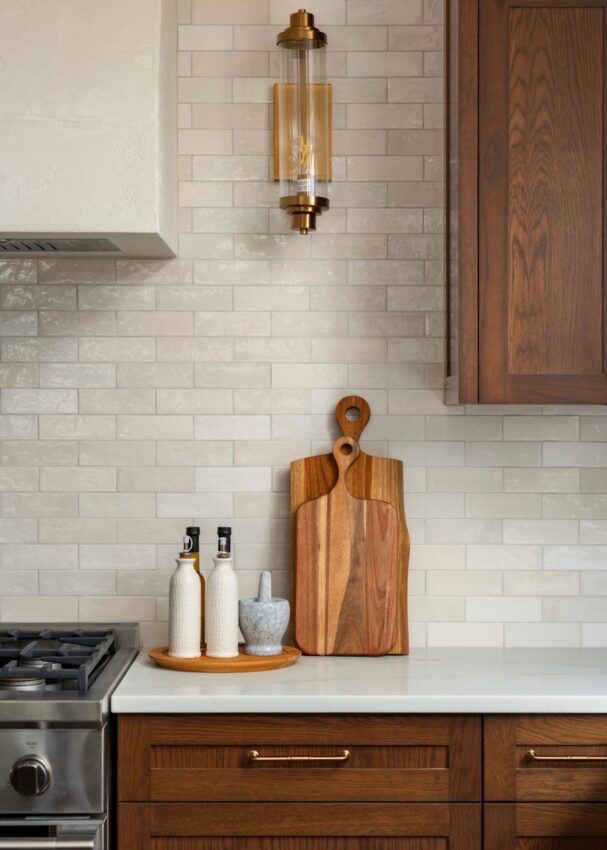 A modern kitchen with wooden cabinets and white tile.