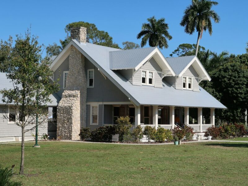 brown and white concrete house near green grass field during daytime