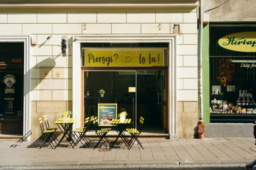 a person walking past a store front with tables and chairs