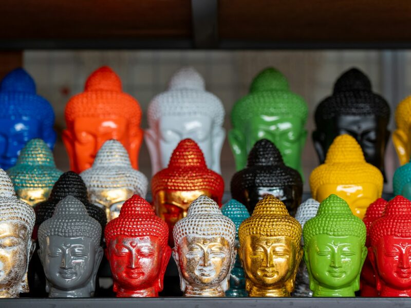 a group of buddha heads sitting on top of a shelf