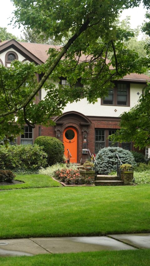 A house with a red door and a green lawn