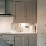 A kitchen with white cabinets and a black oven
