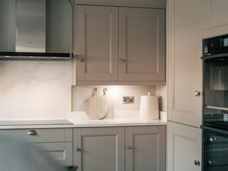 A kitchen with white cabinets and a black oven