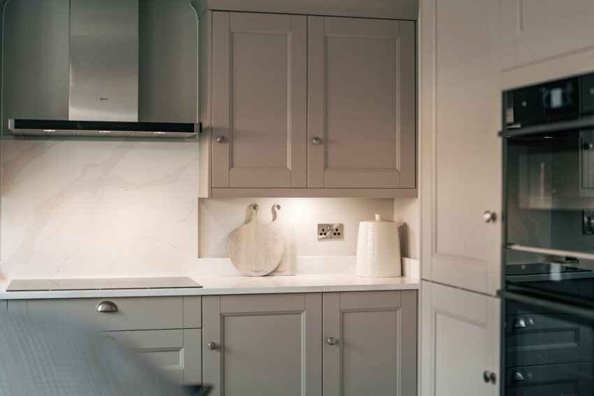 A kitchen with white cabinets and a black oven
