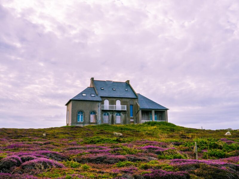 white and gray house under cloudy sky