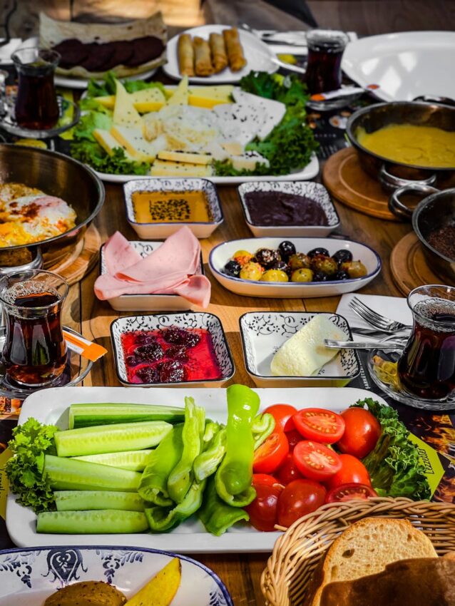 A colorful and abundant Turkish breakfast spread featuring vegetables, cheeses, and traditional dishes.