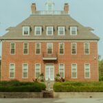 a red brick house with a white door and windows