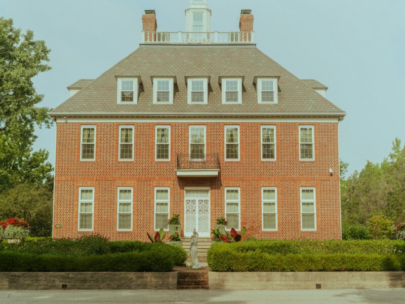 a red brick house with a white door and windows