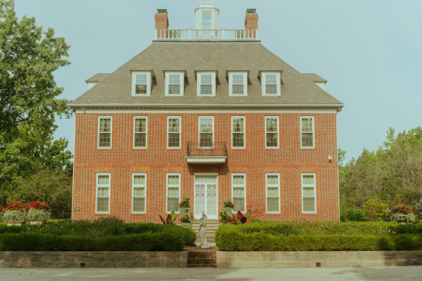 a red brick house with a white door and windows