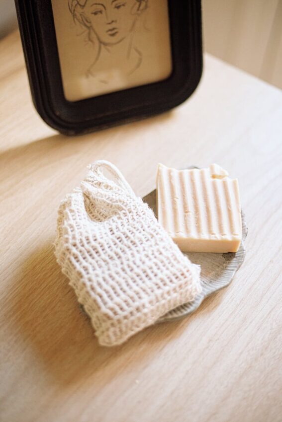 A rustic soap bar and luffa displayed in soft natural light, emphasizing eco-friendly skincare.