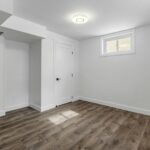 an empty room with white walls and wooden floors