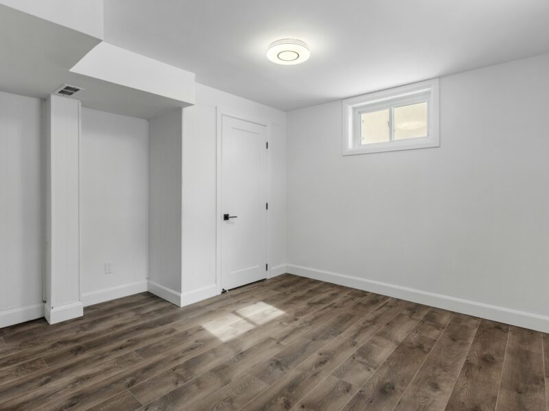 an empty room with white walls and wooden floors