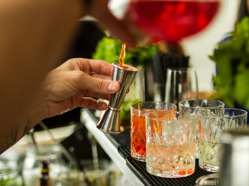 a person is pouring a drink into a glass