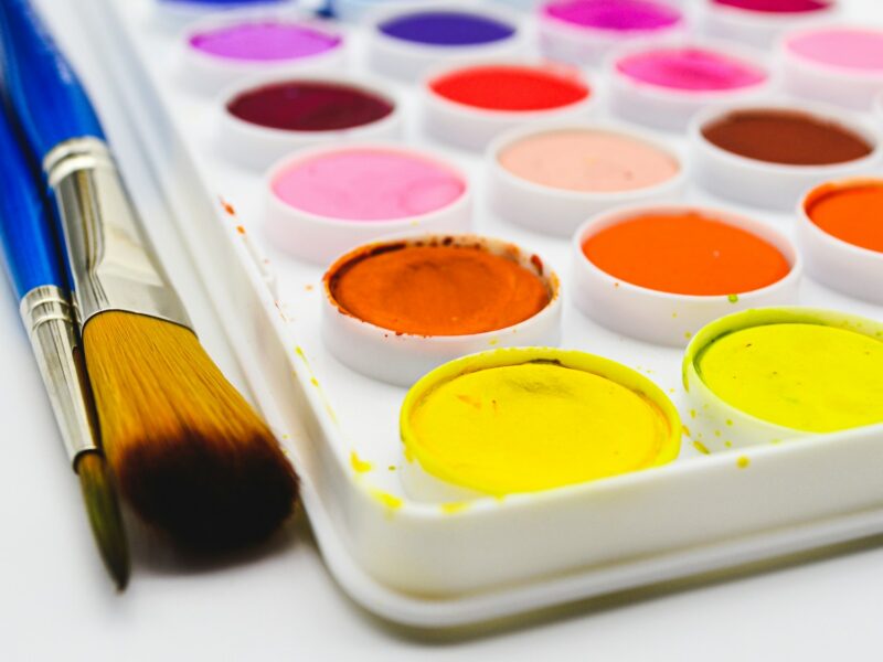 a tray of paint and a brush on a table