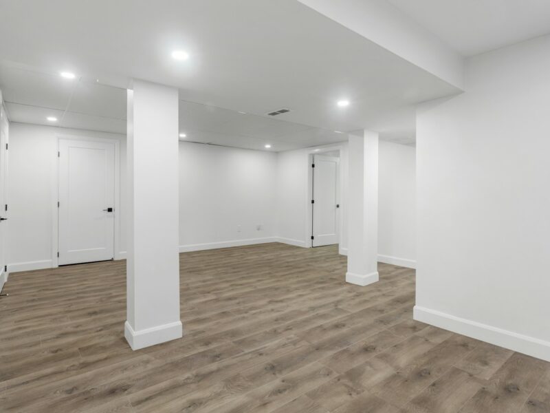 an empty room with white walls and wooden floors