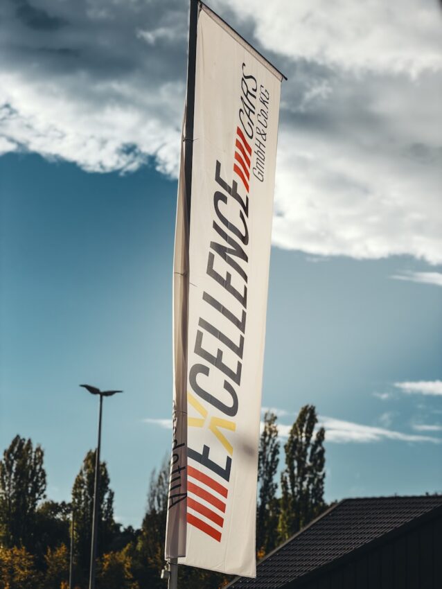 White flag with "excellence cars" logo