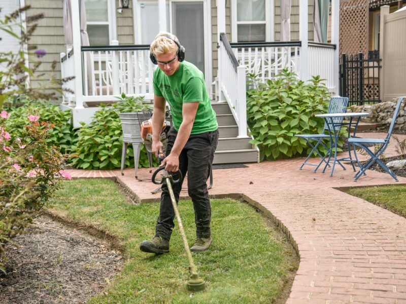man in green t-shirt and black pants holding black and brown shovel