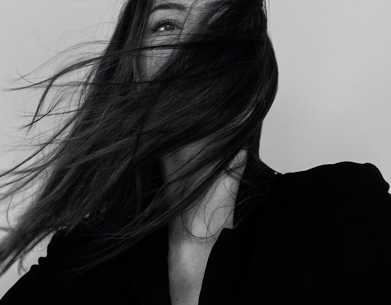 grayscale photography of woman wearing long-sleeved shirt