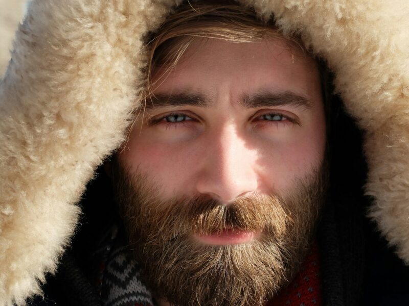 man covered by beige fur textile