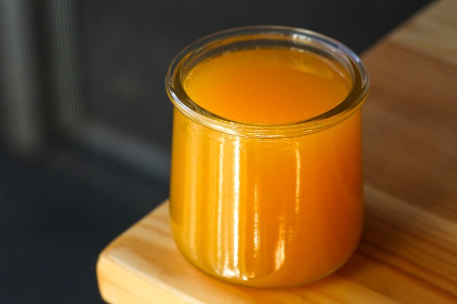 A glass of orange juice on wood.