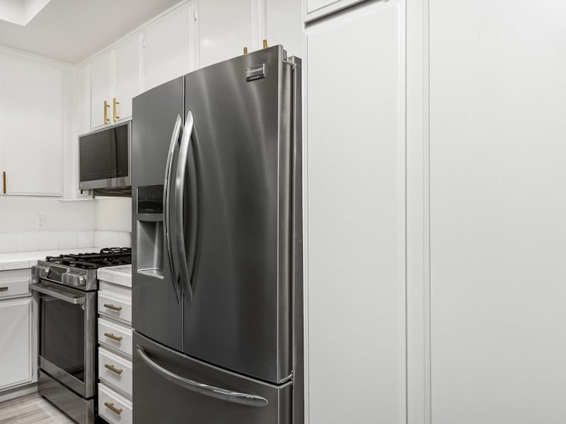 A kitchen with white cabinets and stainless steel appliances