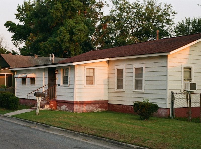 white and brown wooden house near green trees during daytime