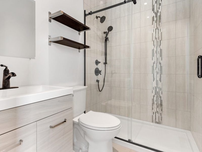a bathroom with a shower unit and toilet