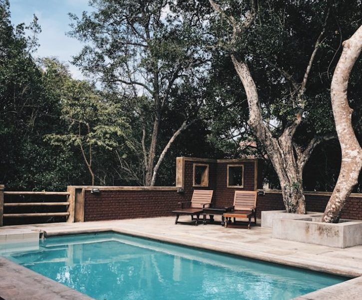 two lounge chairs near swimming pool