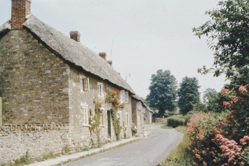 A traditional brick English house set among mature trees, echoing the period homes found in Fetcham.